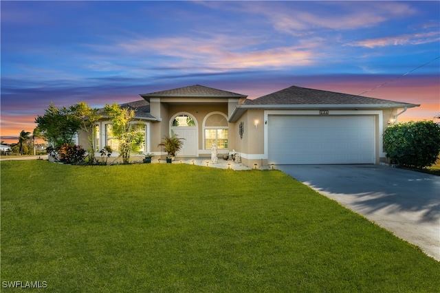 view of front facade with a garage and a yard