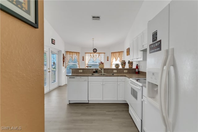 kitchen featuring white cabinetry, sink, kitchen peninsula, decorative light fixtures, and white appliances