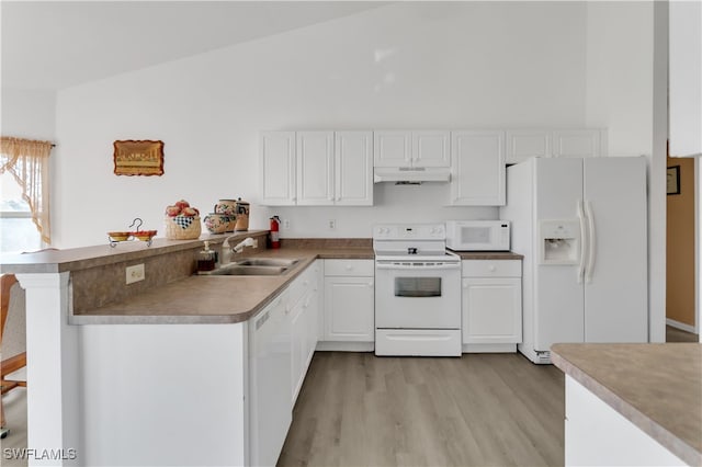 kitchen featuring white appliances, sink, vaulted ceiling, and kitchen peninsula