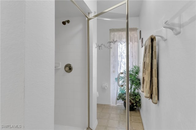 bathroom with a shower with door