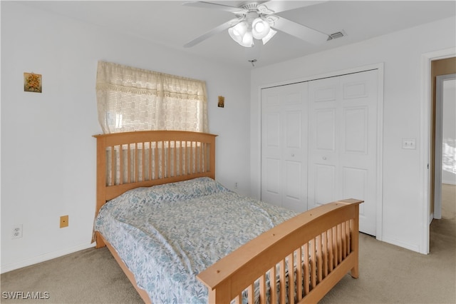 bedroom featuring a closet, light colored carpet, and ceiling fan