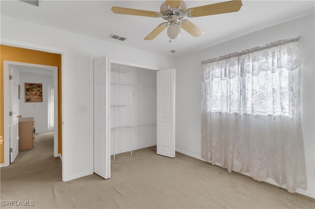 unfurnished bedroom with a closet, light carpet, and ceiling fan