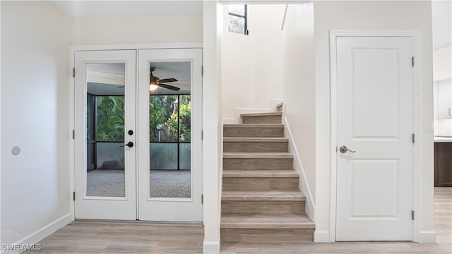 stairway with ceiling fan, baseboards, wood finished floors, and french doors