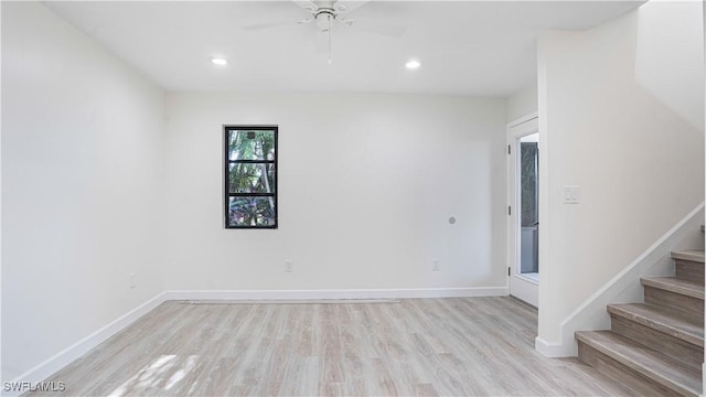 spare room with stairs, recessed lighting, light wood-type flooring, and baseboards