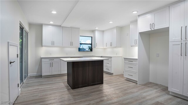 kitchen with a center island, white cabinets, and light hardwood / wood-style floors