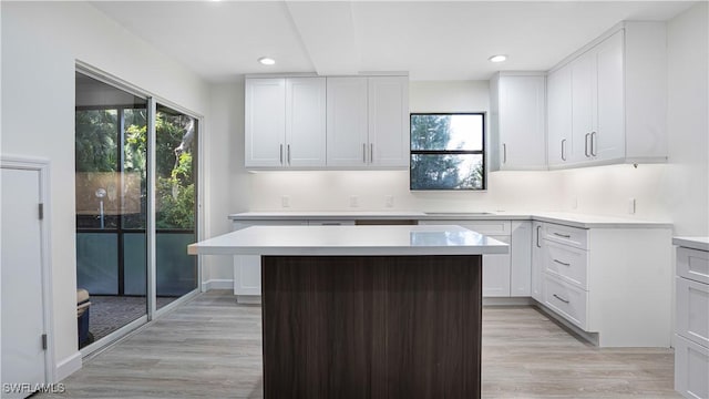 kitchen featuring white cabinets, plenty of natural light, a kitchen island, and light countertops