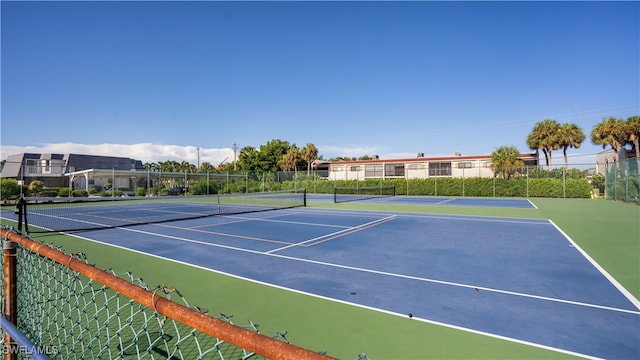 view of tennis court featuring basketball hoop