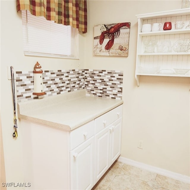 kitchen with light tile patterned floors and white cabinets