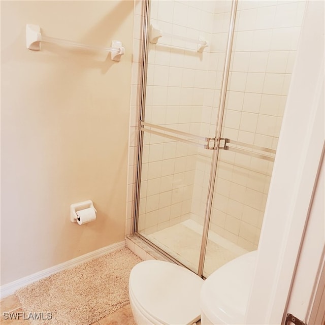 bathroom featuring toilet and an enclosed shower