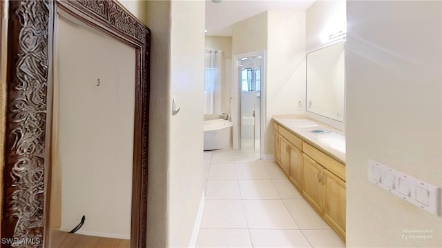 bathroom with a bath, vanity, and tile patterned floors