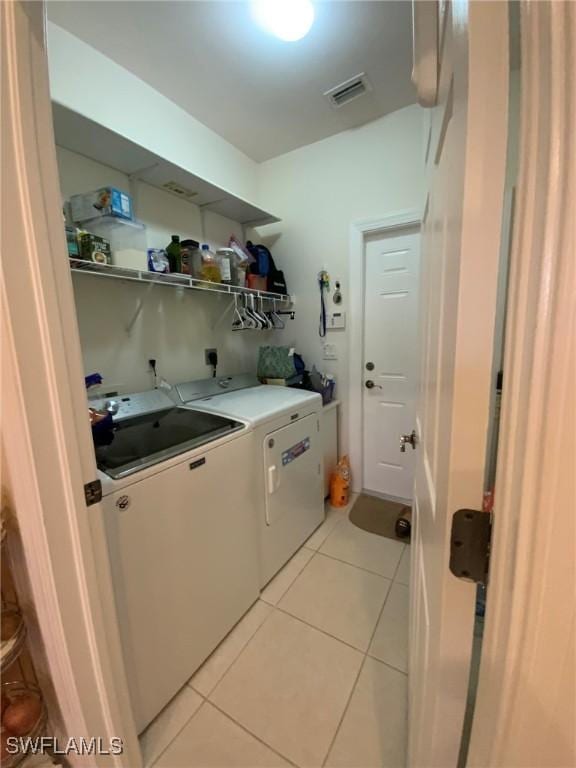 laundry area featuring independent washer and dryer, light tile patterned floors, and sink