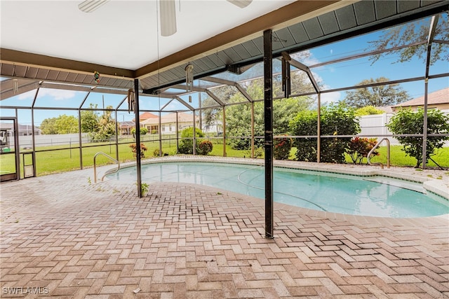 pool featuring glass enclosure, a patio area, a yard, and fence