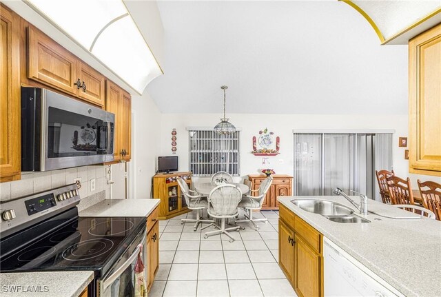 kitchen featuring light tile patterned flooring, appliances with stainless steel finishes, light countertops, and a sink