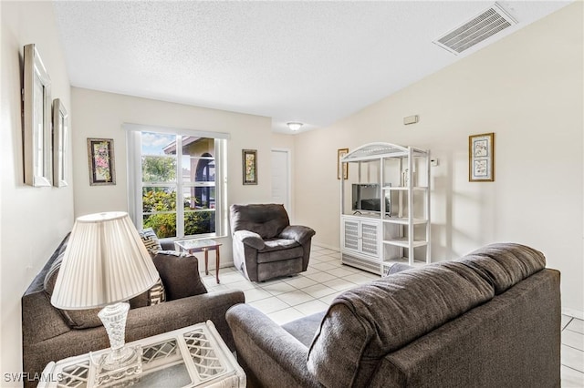 living area featuring light tile patterned floors, visible vents, and a textured ceiling