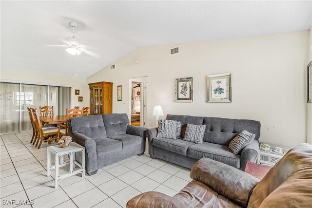 living area with lofted ceiling, light tile patterned floors, a ceiling fan, and visible vents