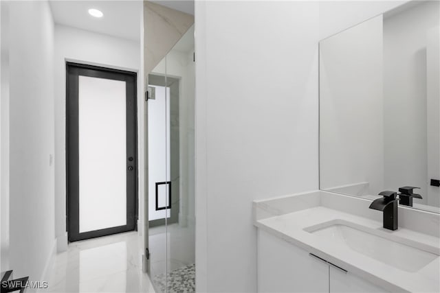 bathroom featuring vanity and a shower with shower door