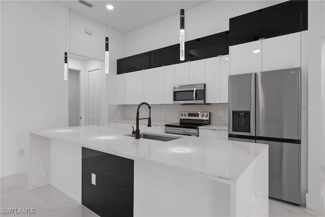 kitchen featuring sink, a kitchen island with sink, hanging light fixtures, and stainless steel appliances