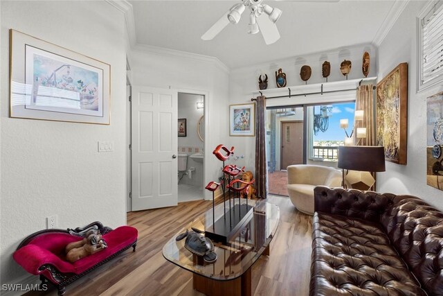 living room with wood-type flooring, ceiling fan, and crown molding