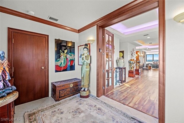 entrance foyer with crown molding and light hardwood / wood-style flooring