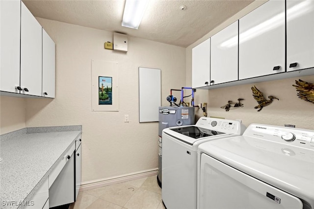 clothes washing area featuring independent washer and dryer, a textured ceiling, water heater, cabinet space, and baseboards