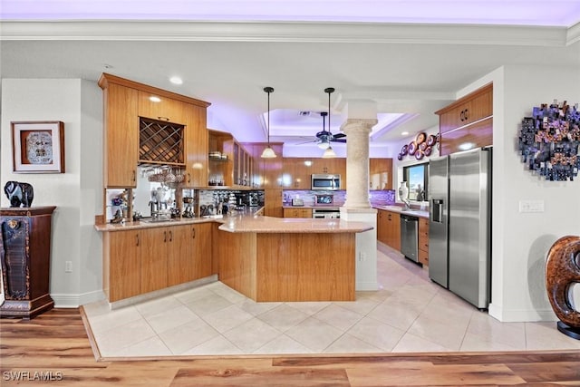 kitchen featuring ceiling fan, light tile patterned floors, appliances with stainless steel finishes, a peninsula, and ornate columns