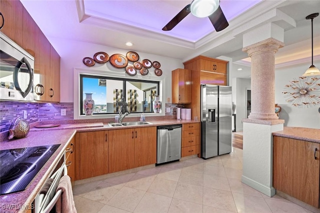 kitchen featuring ornate columns, sink, stainless steel appliances, tasteful backsplash, and decorative light fixtures