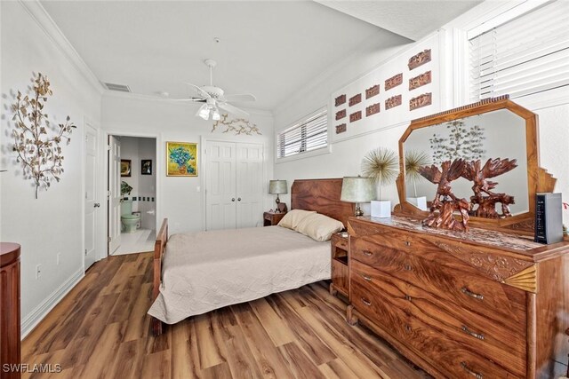 bedroom with ceiling fan, crown molding, wood-type flooring, connected bathroom, and a closet