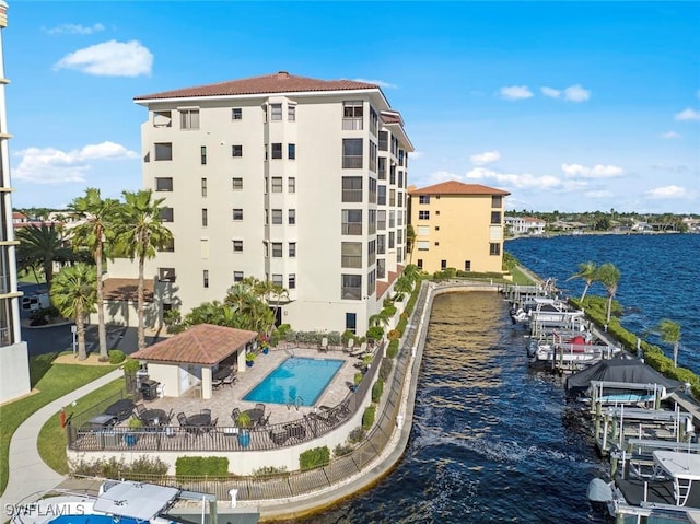 exterior space with a water view, a community pool, and fence