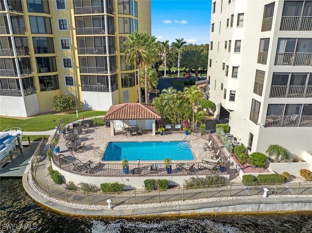 pool featuring a gazebo, a water view, a patio, and fence