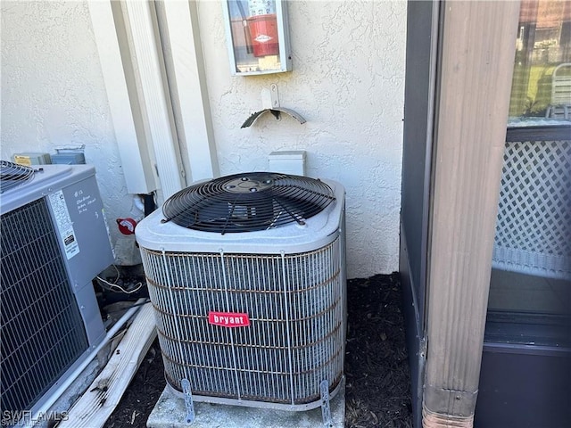 details with cooling unit, a fire extinguisher, and stucco siding