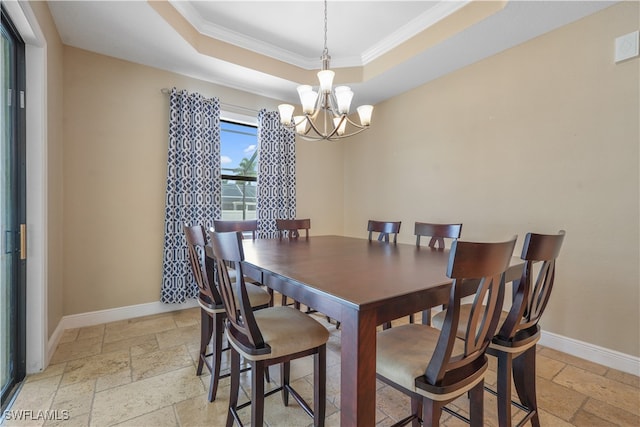 dining room featuring a tray ceiling, crown molding, and a chandelier