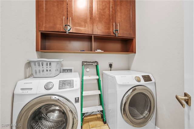 laundry room featuring cabinets and washer and dryer