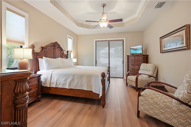 bedroom featuring a tray ceiling, access to outside, ceiling fan, and light hardwood / wood-style floors