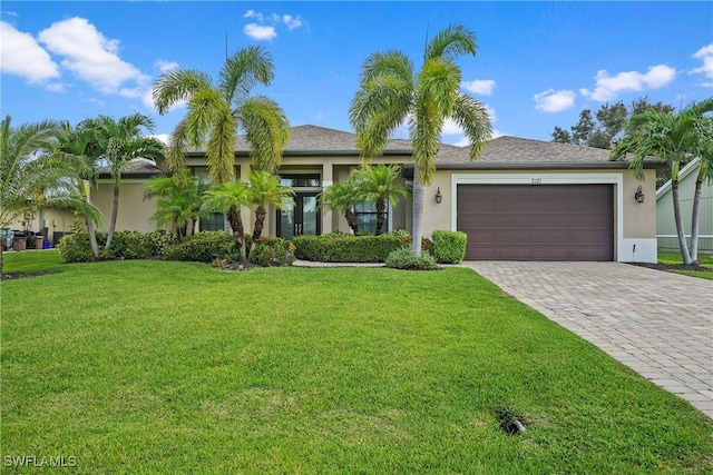 view of front of property with a front yard and a garage