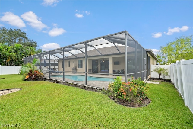 back of house with a lawn, a fenced in pool, and glass enclosure