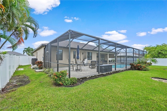 back of house featuring a lanai, a fenced in pool, a lawn, and a patio area