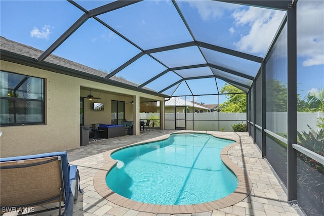 view of pool with glass enclosure, ceiling fan, and a patio