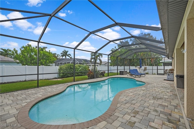 view of pool featuring glass enclosure and a patio