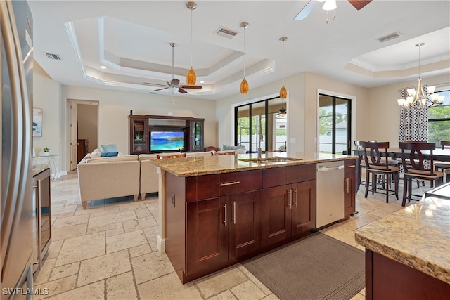 kitchen with a tray ceiling and ceiling fan with notable chandelier