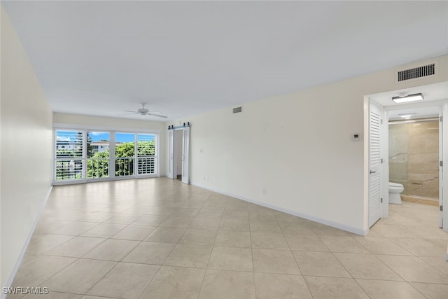 empty room featuring ceiling fan and light tile patterned floors