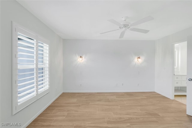 empty room with ceiling fan and light hardwood / wood-style floors