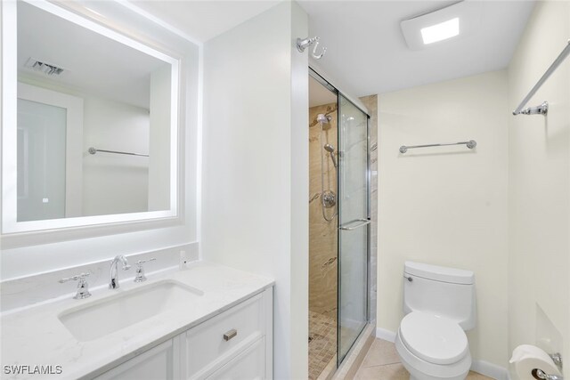 bathroom with tile patterned flooring, vanity, toilet, and an enclosed shower