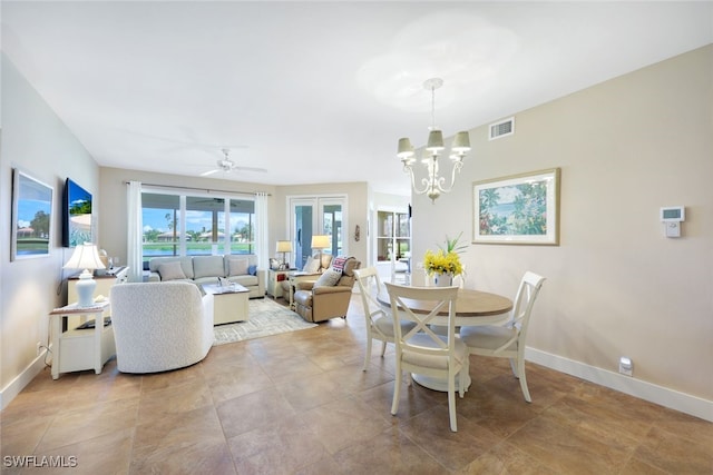 dining space with ceiling fan with notable chandelier