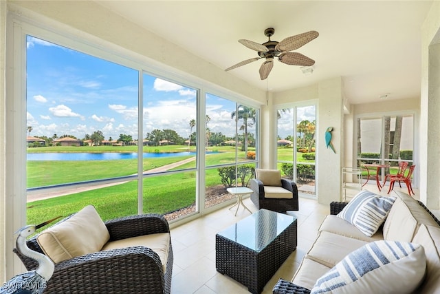 sunroom / solarium featuring ceiling fan and a water view