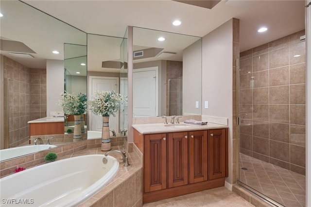 bathroom featuring plus walk in shower, vanity, and tile patterned flooring