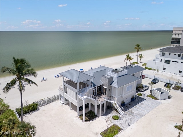 drone / aerial view featuring a water view and a view of the beach