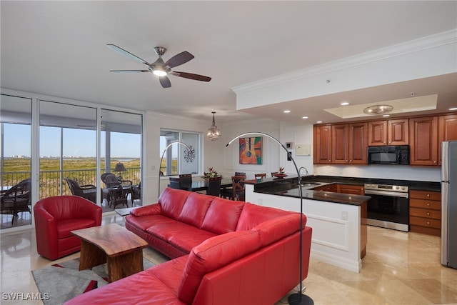 tiled living room featuring ceiling fan with notable chandelier, crown molding, and sink