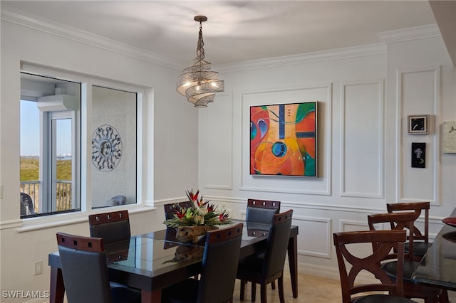 dining space with crown molding and a chandelier