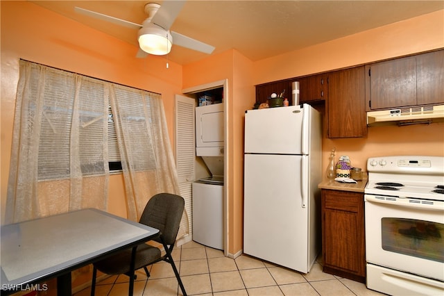 kitchen with stacked washing maching and dryer, ceiling fan, light tile patterned floors, and white appliances