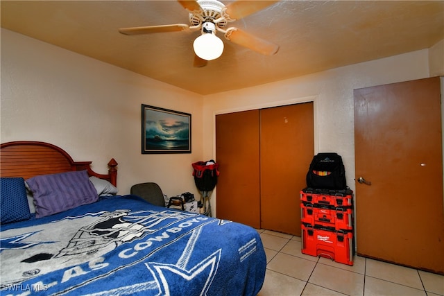 tiled bedroom with ceiling fan and a closet